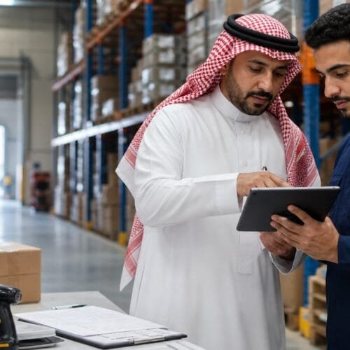 مدرب ومتدرب سعوديان يراجعان تدفق الشحنات داخل مستودع حديث